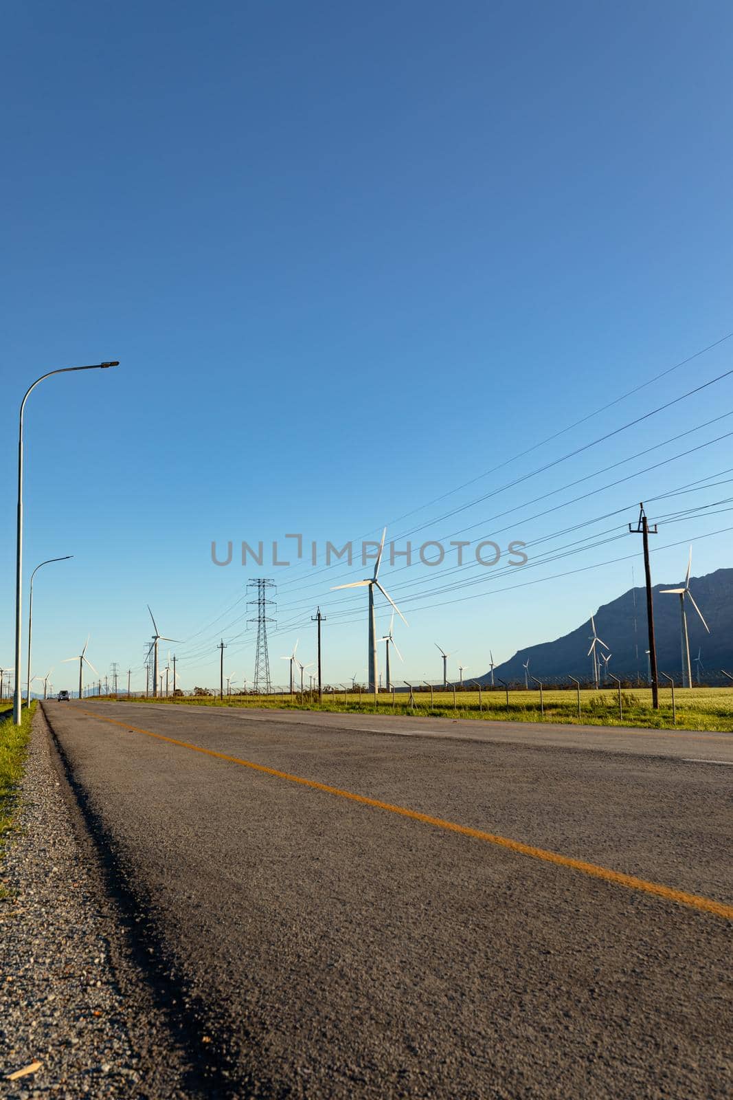 General view of wind turbines in countryside landscape with cloudless sky by Wavebreakmedia