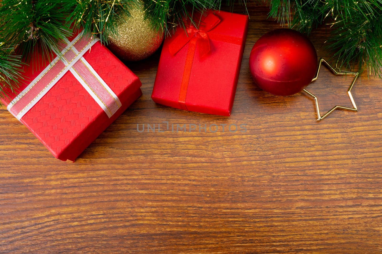 Composition of christmas decorations with presents, baubles and copy space on wooden background. christmas, tradition and celebration concept.