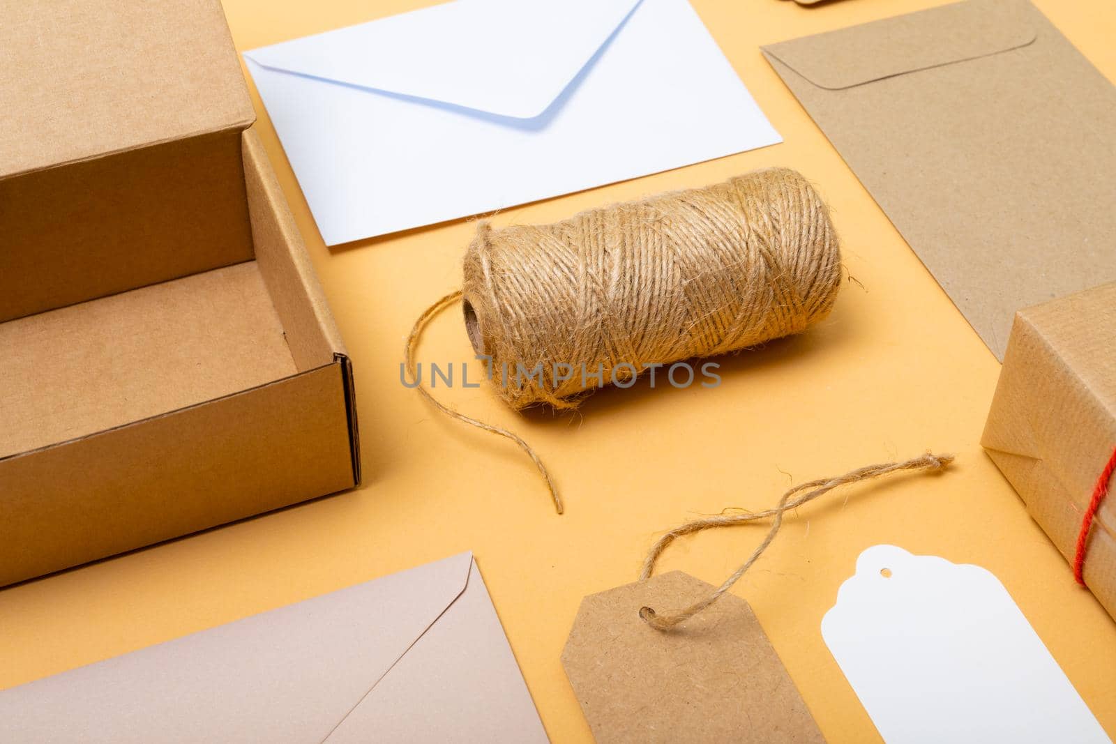Composition of boxes, envelopes and gift tags on yellow background. christmas, gifts, tradition and celebration concept.