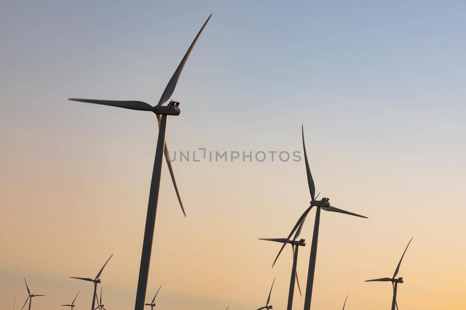 General view of wind turbines in countryside landscape with cloudless sky. environment, sustainability, ecology, renewable energy, global warming and climate change awareness.