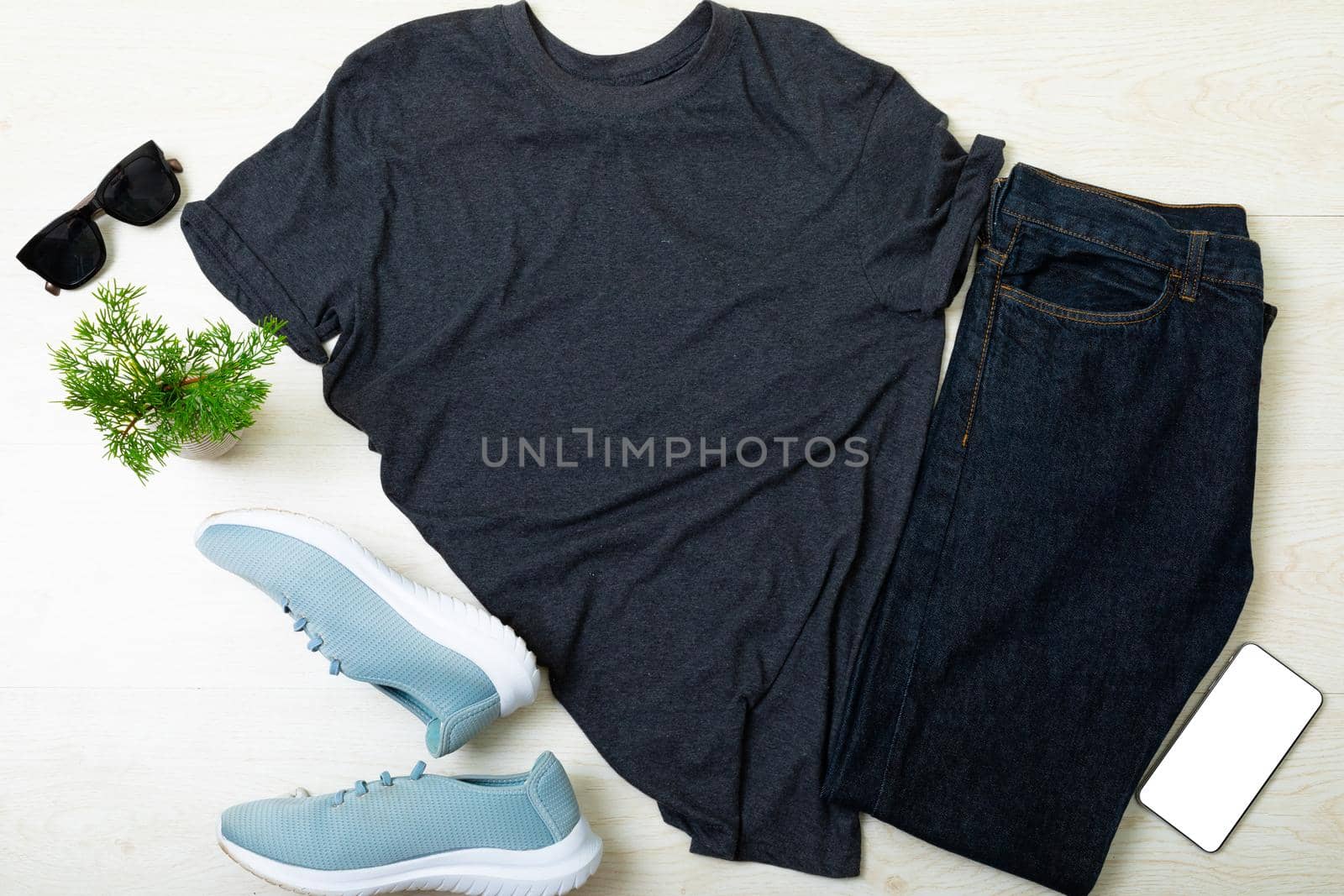 Composition of clothes, shoes, sunglasses, smartphone and tree branches on wooden background. technology, fashion and accessories concept.