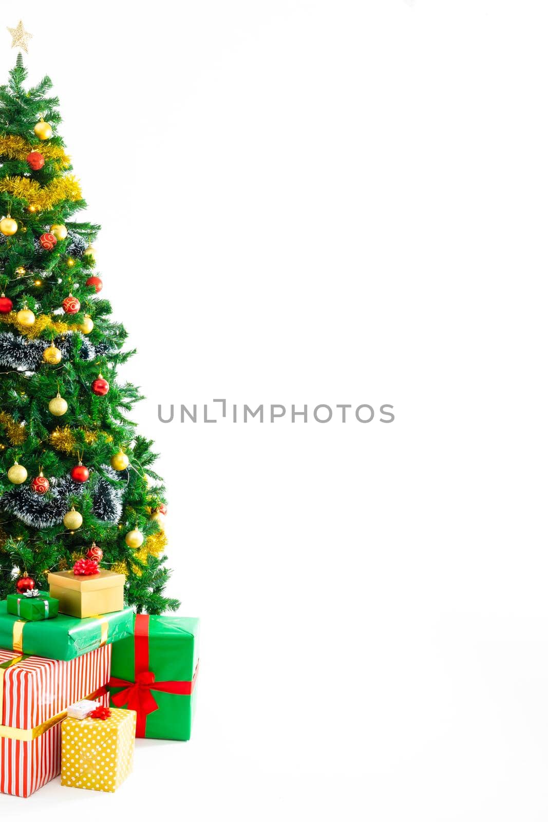 Composition of christmas tree with decorations, presents and copy space on white background by Wavebreakmedia