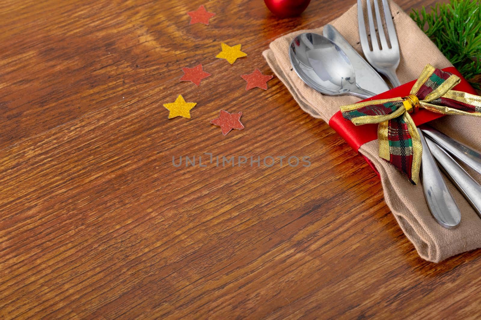 Composition of christmas decorations with cutlery and copy space on wooden background by Wavebreakmedia