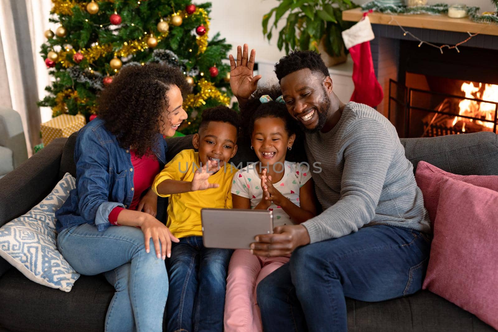 Happy african american family having video call on tablet, christmas decorations in background by Wavebreakmedia