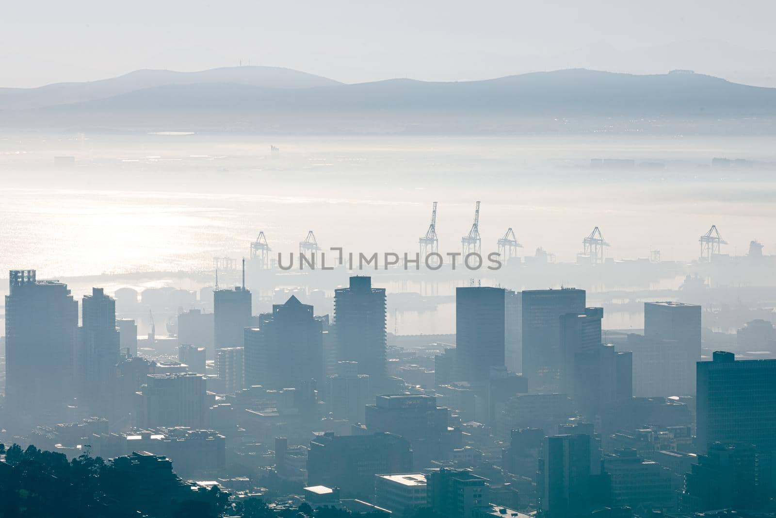 General view of cityscape with multiple modern buildings and cranes in the foggy morning by Wavebreakmedia