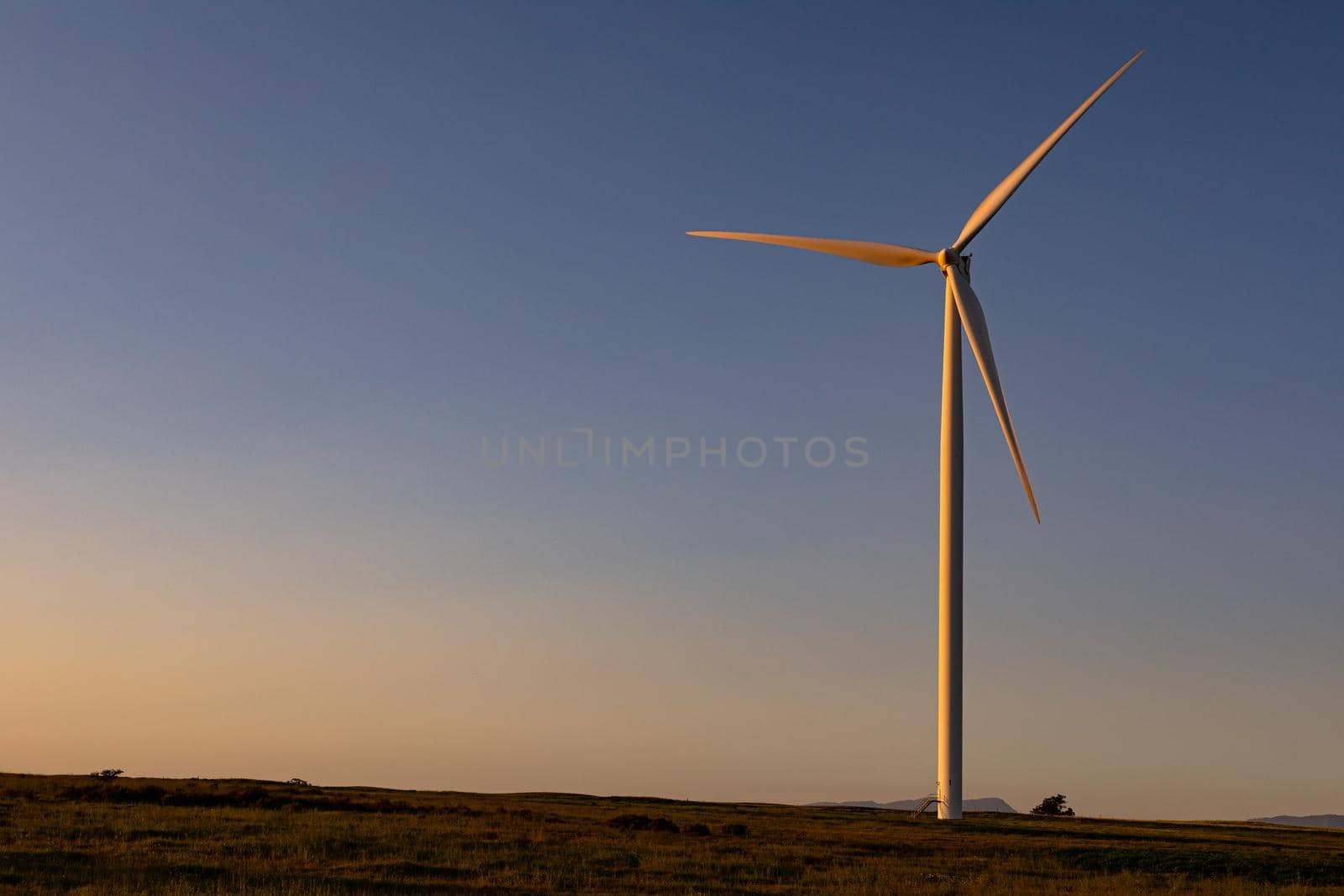 General view of wind turbine in countryside landscape during sunset. environment, sustainability, ecology, renewable energy, global warming and climate change awareness.