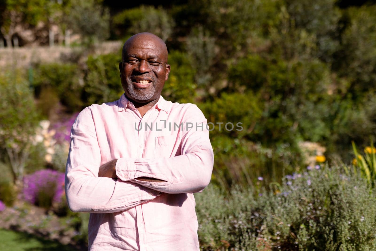 Portrait of happy african american senior man taking photo outdoors. retirement lifestyle, spending time at home and garden.