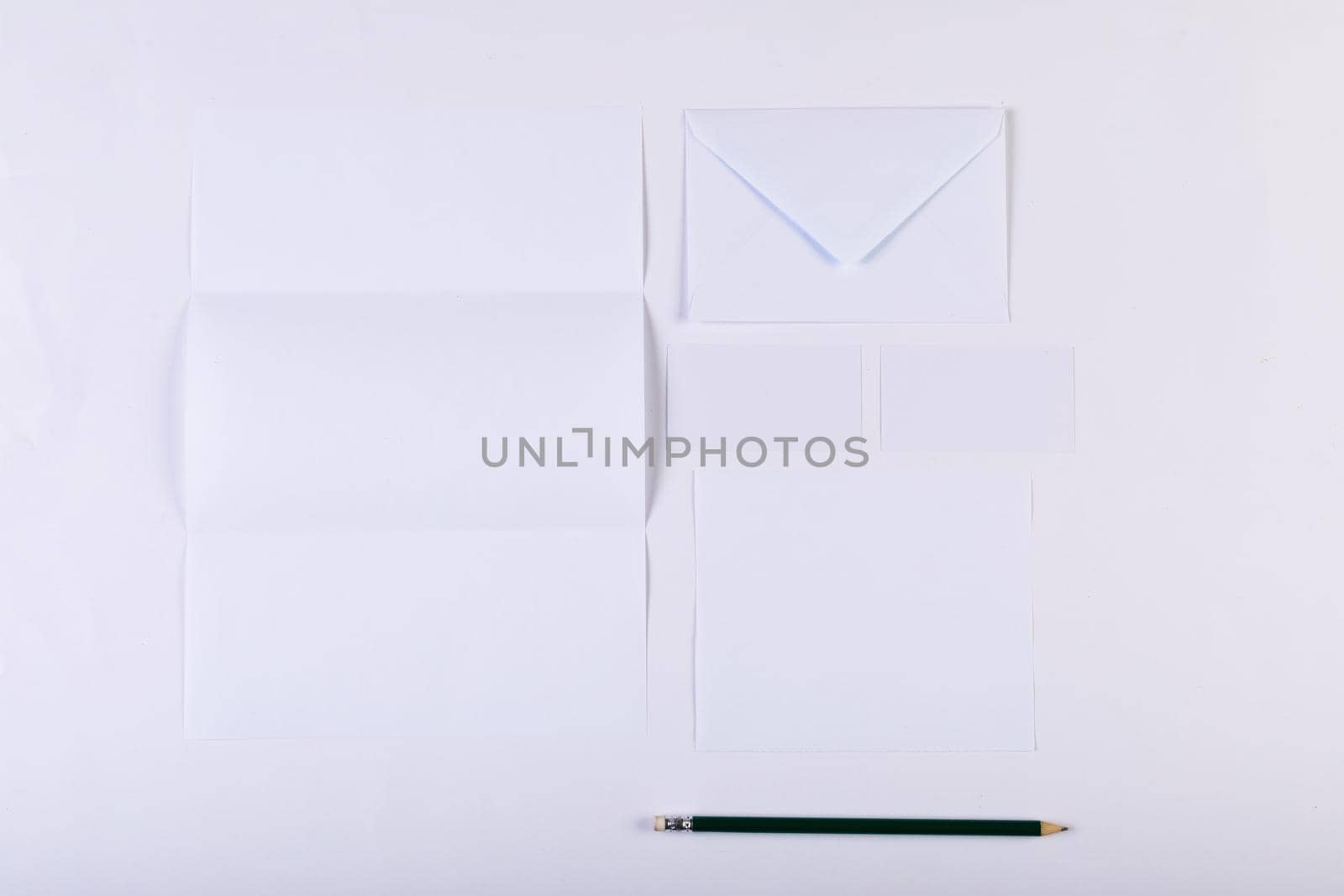 Composition of white cards and envelopes with pencil on white background by Wavebreakmedia