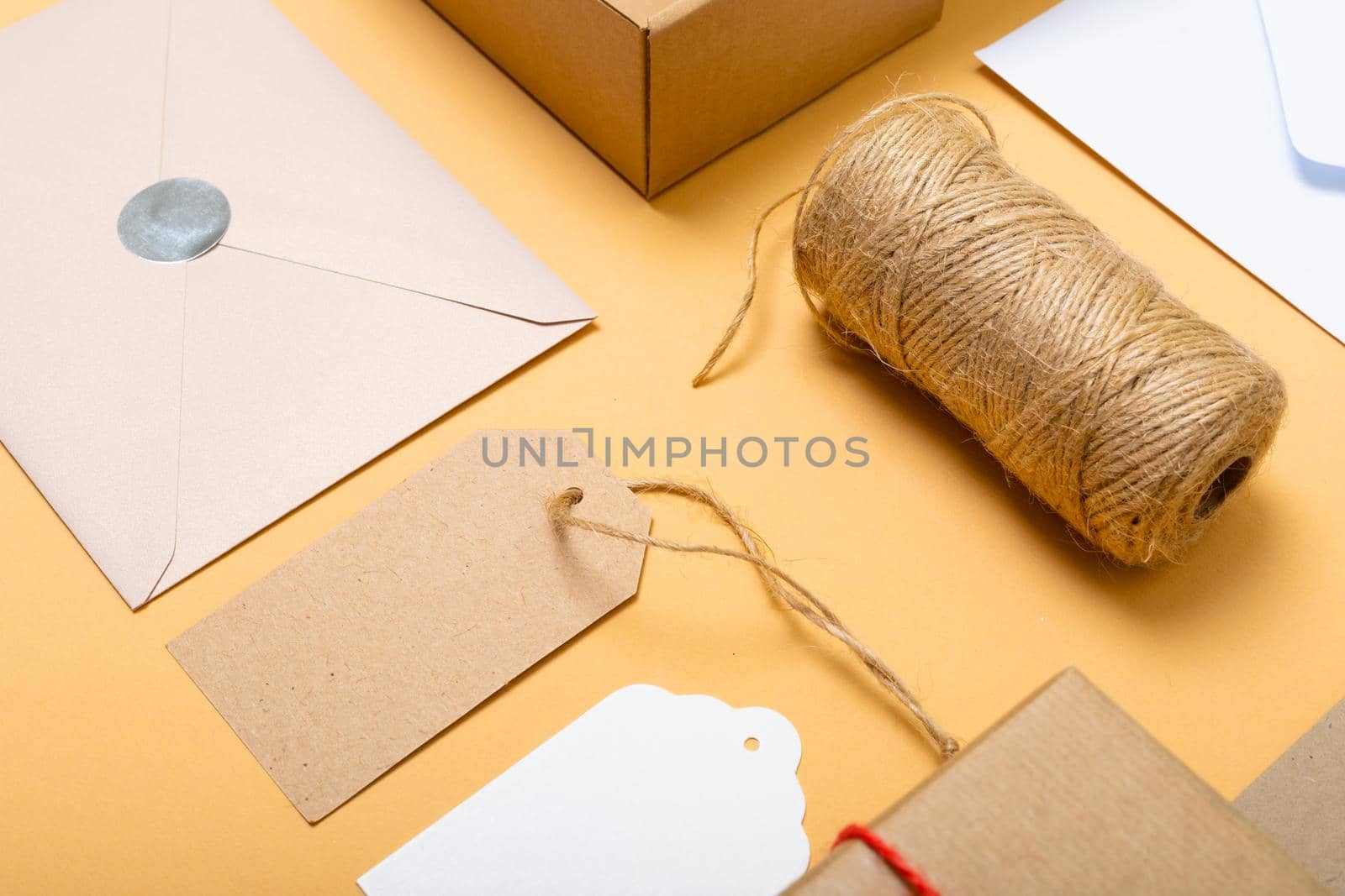 Composition of boxes, envelopes and gift tags on yellow background. christmas, gifts, tradition and celebration concept digitally generated image.
