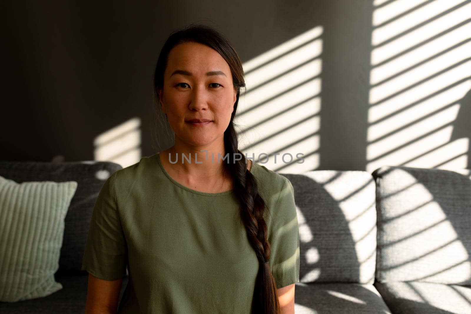 Portrait of serious asian woman sitting on sofa at home. lifestyle, leisure and spending time at home.