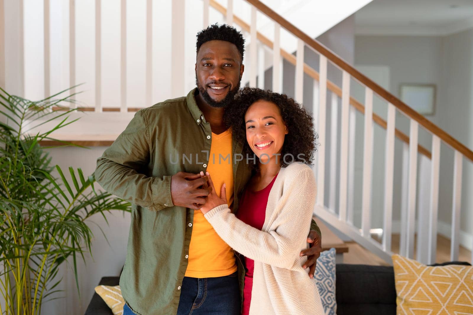 Happy african american couple hugging and looking at camera by Wavebreakmedia