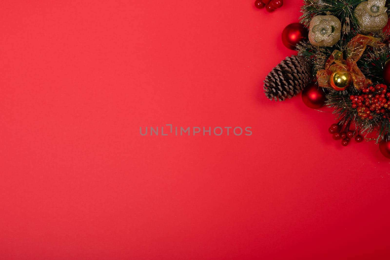 Composition of christmas decorations with pine cones and copy space on red background. christmas, tradition and celebration concept.