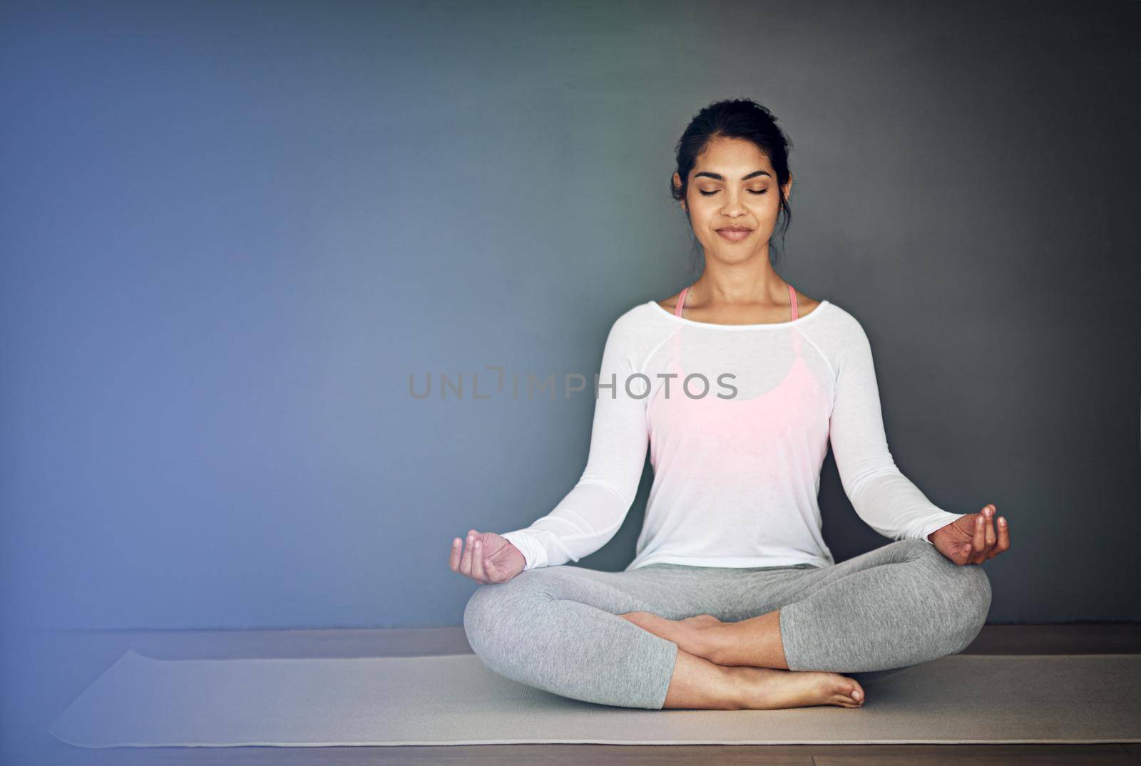Peace begins with me. Shot of an attractive young woman meditating. by YuriArcurs