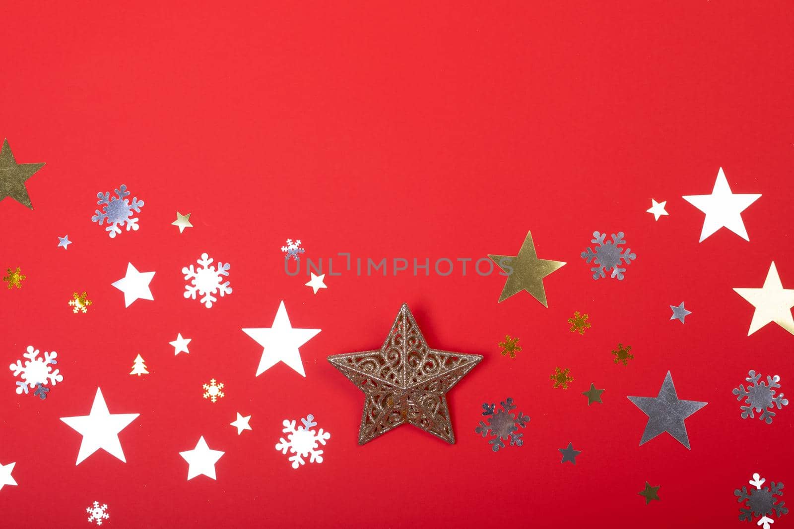 Composition of christmas decorations with stars, snowflakes and copy space on red background. christmas, tradition and celebration concept.