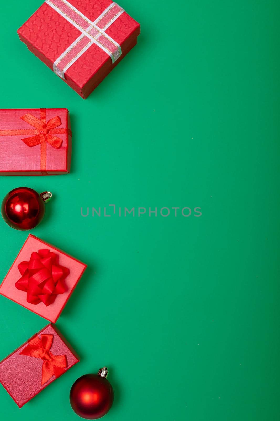 Composition of presents with bauble and copy space on green background. christmas, tradition and celebration concept.