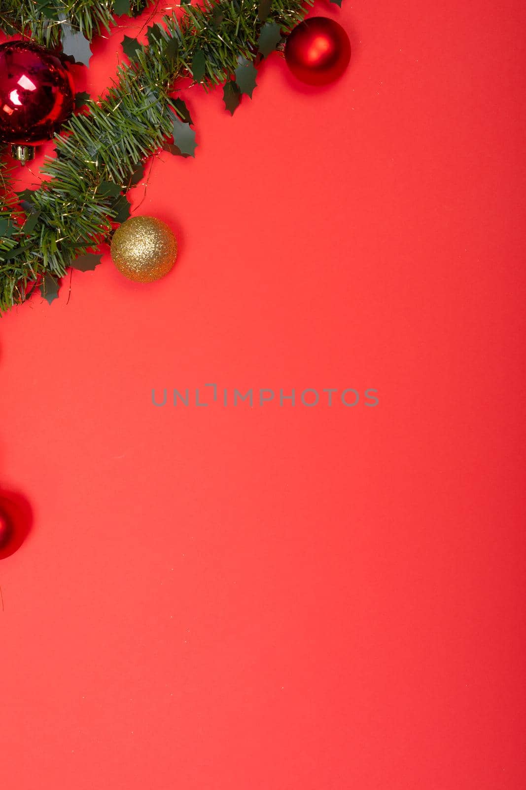 Composition of garland with baubles and copy space on red background by Wavebreakmedia