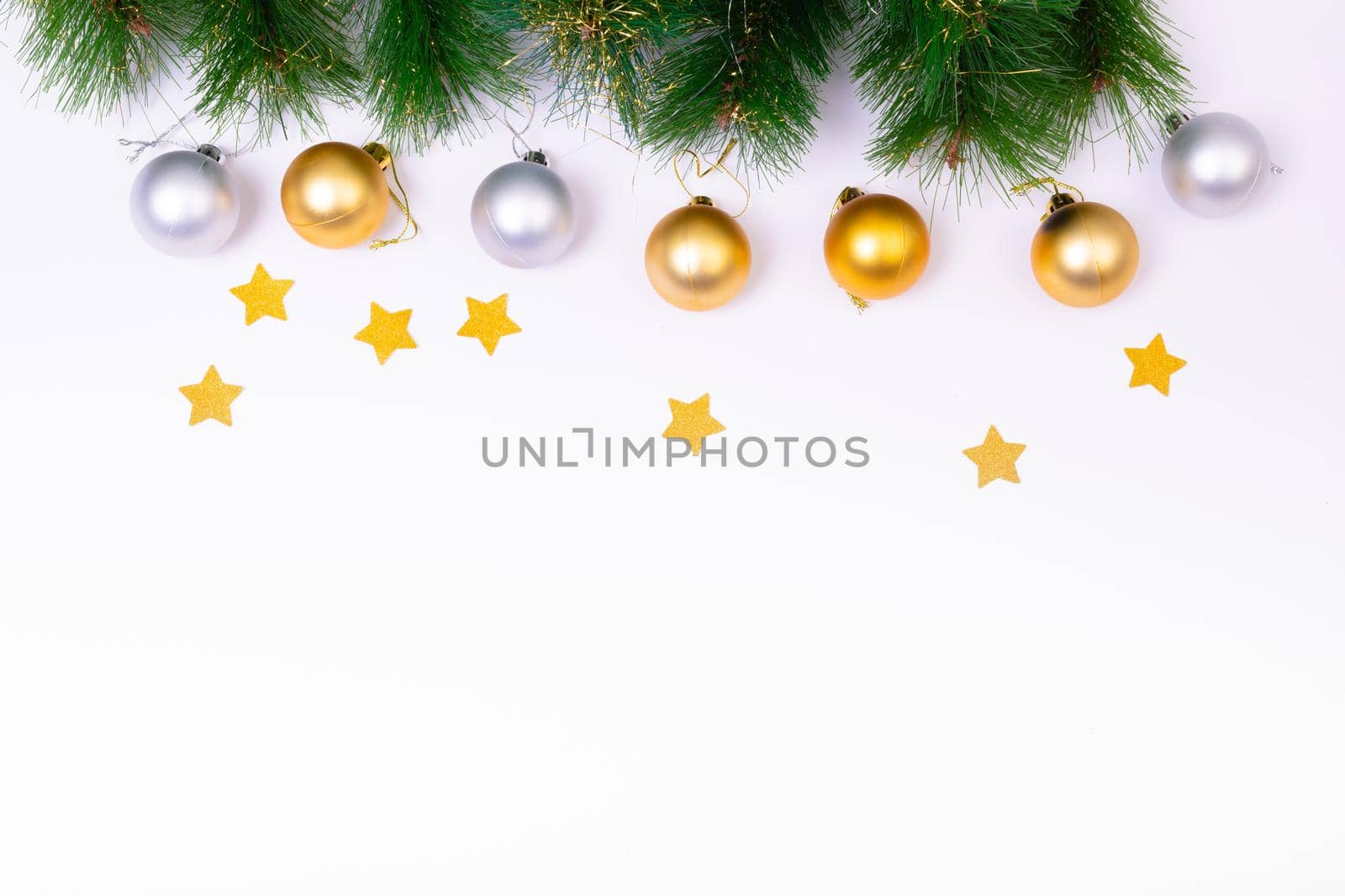 Composition of fir tree branches with baubles, stars and copy space on white background. christmas, tradition and celebration concept.