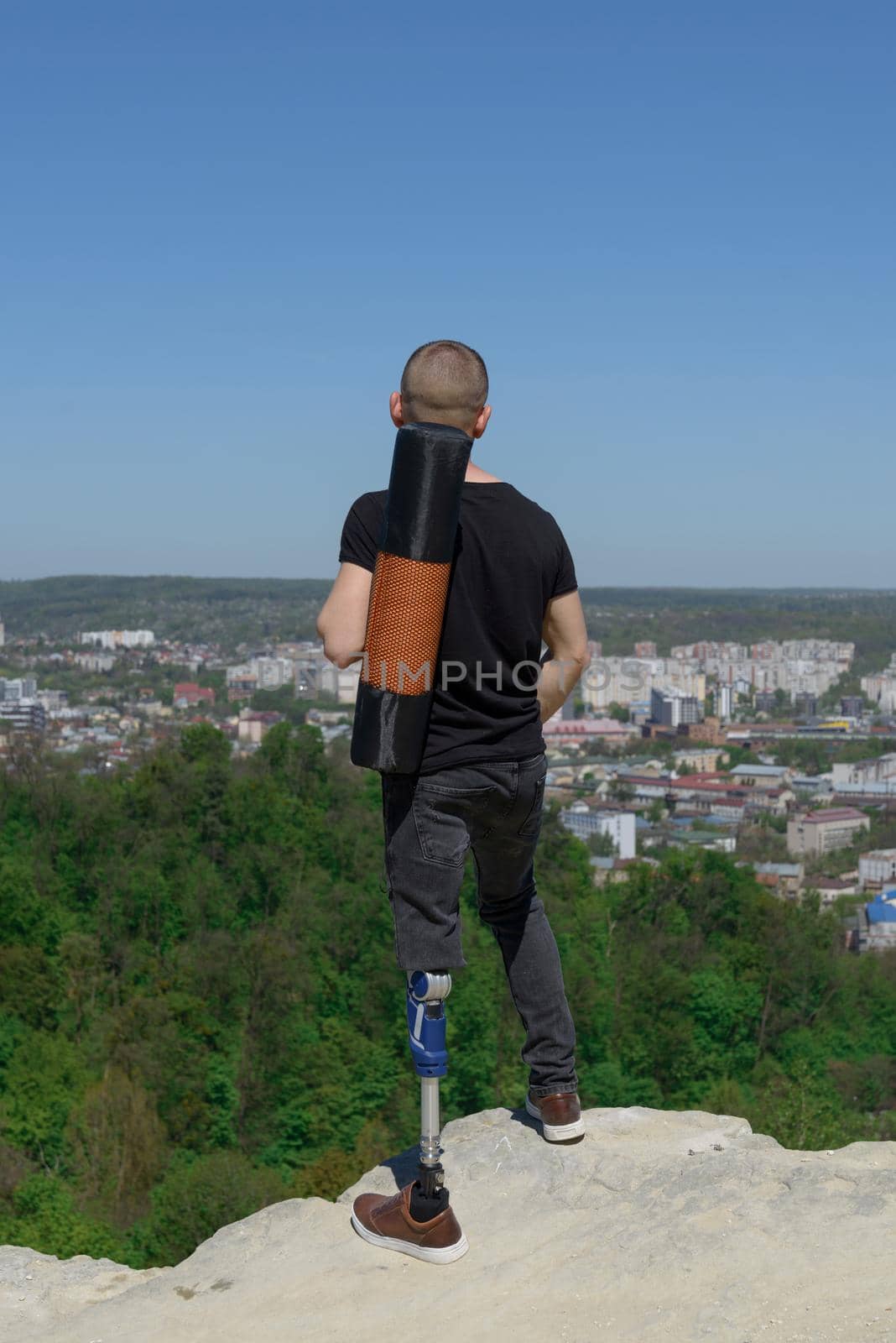 a man on a prosthetic leg travels the mountains. Dressed in black jeans and a T-shirt, he carrying mat by Ashtray25