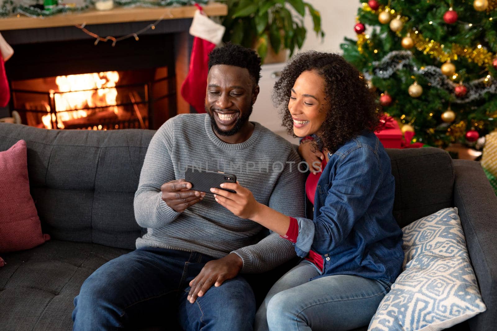 Happy african american couple having video call on smartphone, christmas decorations in background by Wavebreakmedia