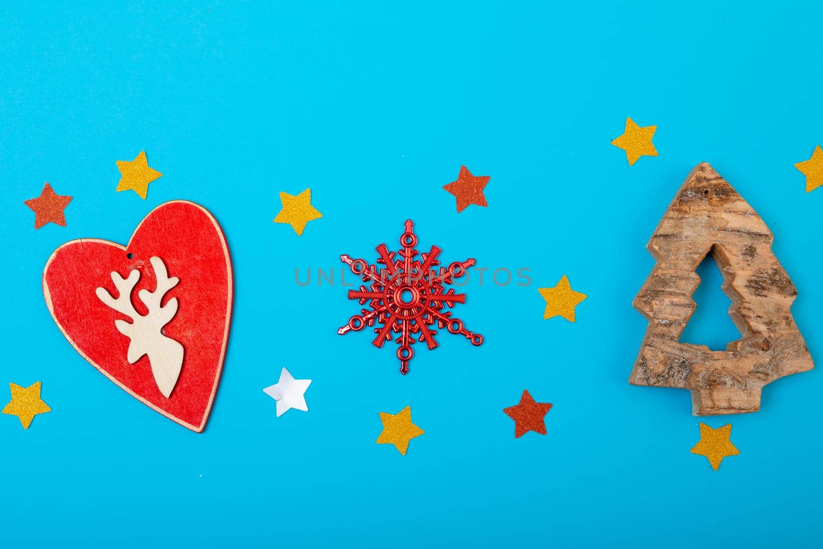 Composition of christmas decorations with heart, stars and copy space on blue background. christmas, tradition and celebration concept.