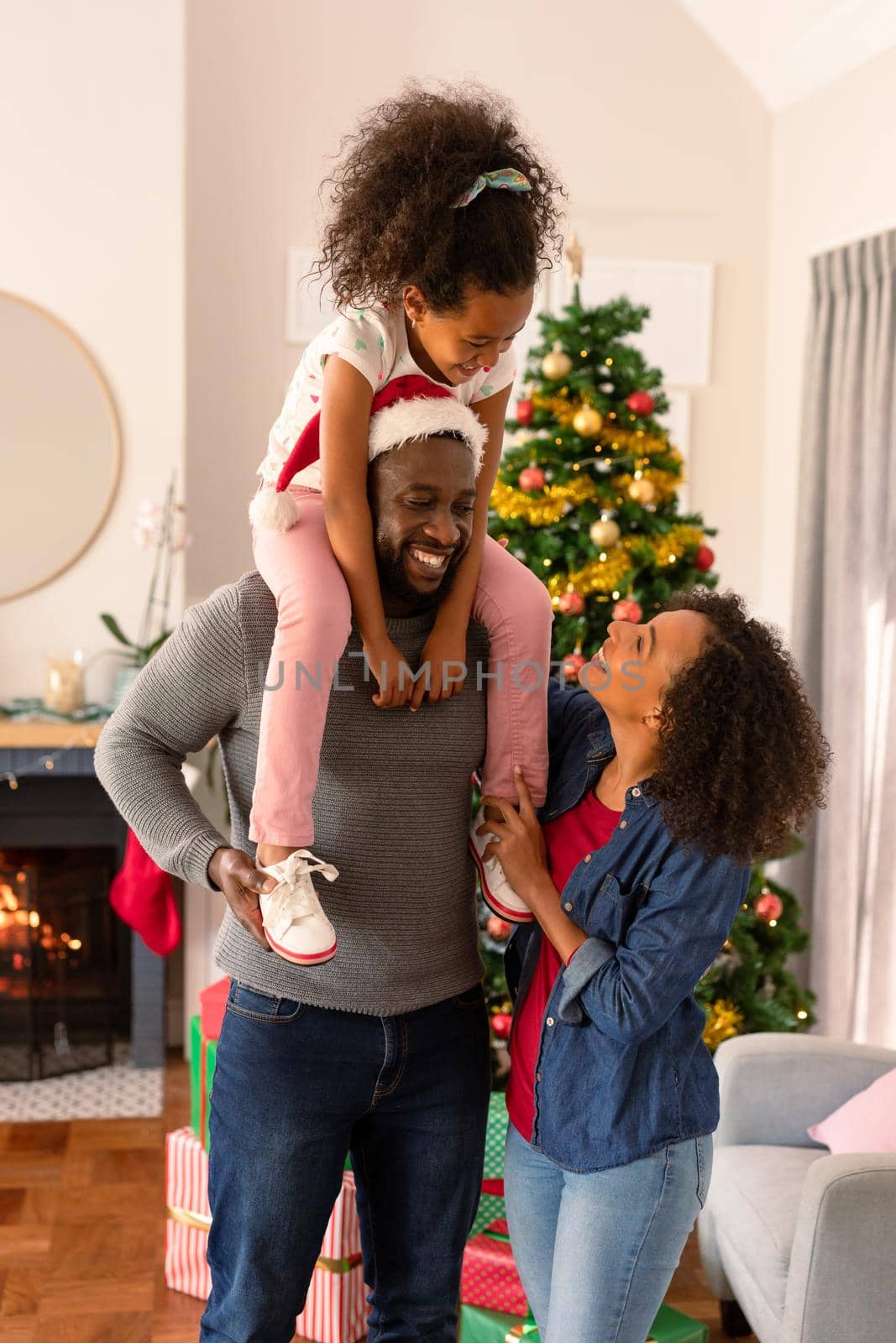 Happy african american parents and daughter posing at camera by Wavebreakmedia