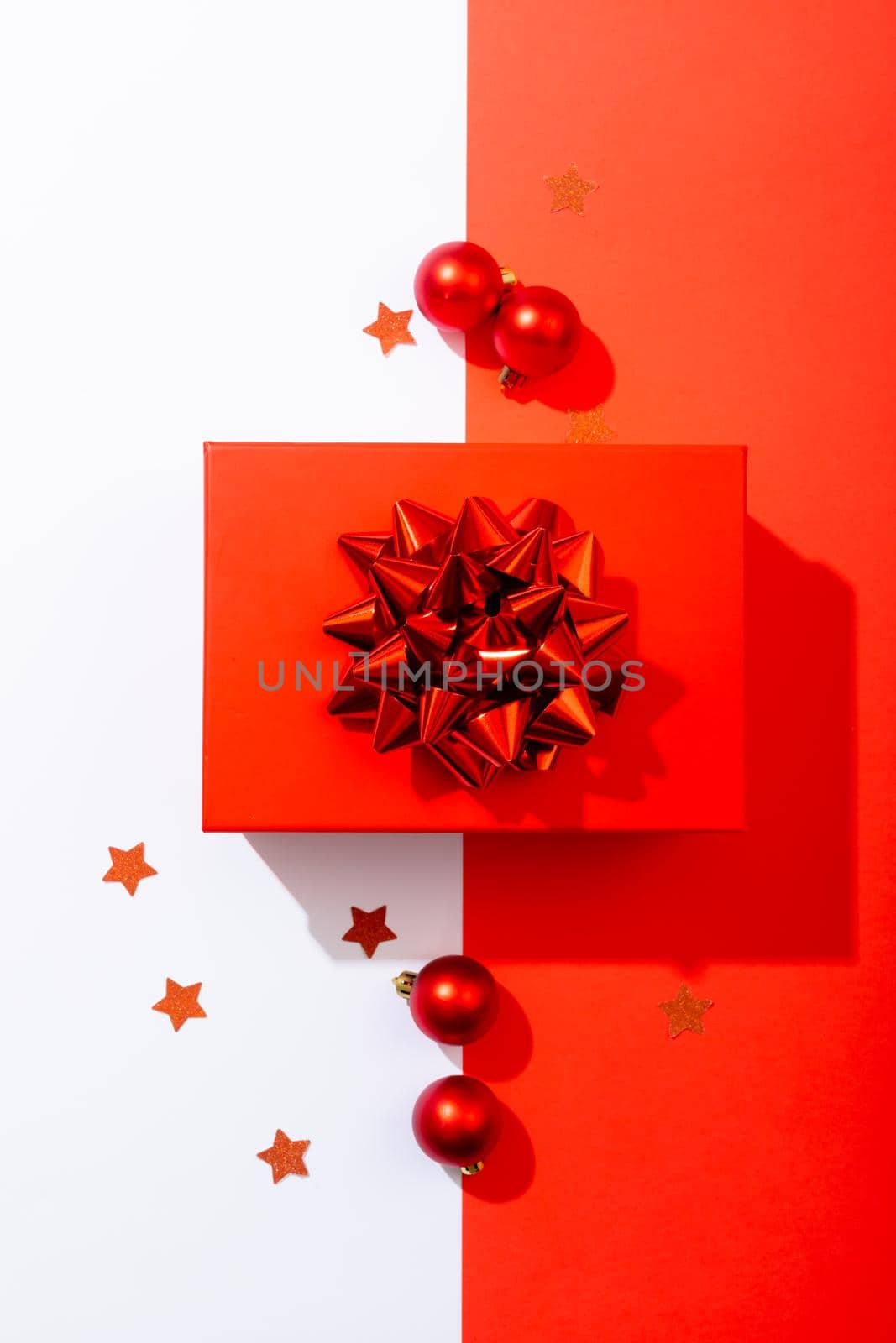 Composition of red christmas present with baubles on white and red background by Wavebreakmedia