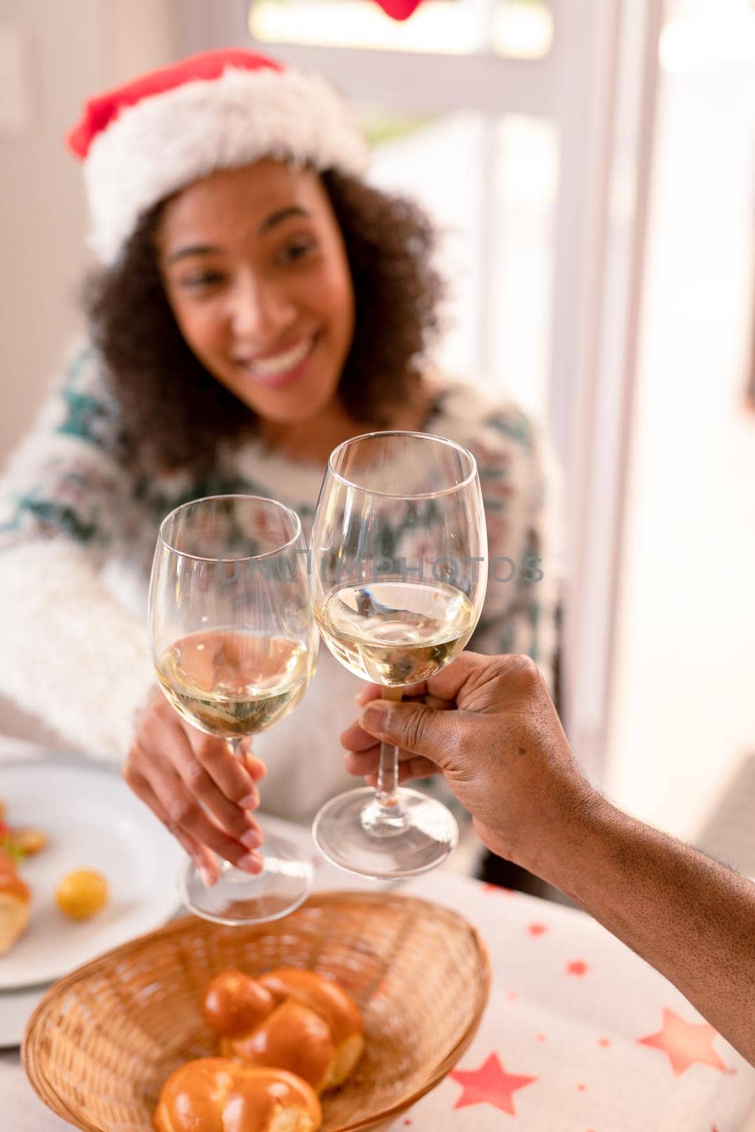 Happy african american woman making toast at christmas table by Wavebreakmedia