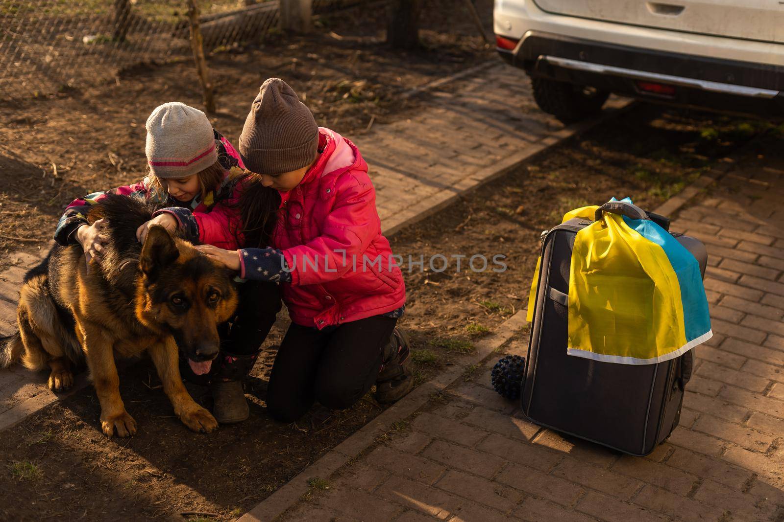 Ukraine military migration. two little girls with a suitcase. Flag of Ukraine, help. Crisis, military conflict.