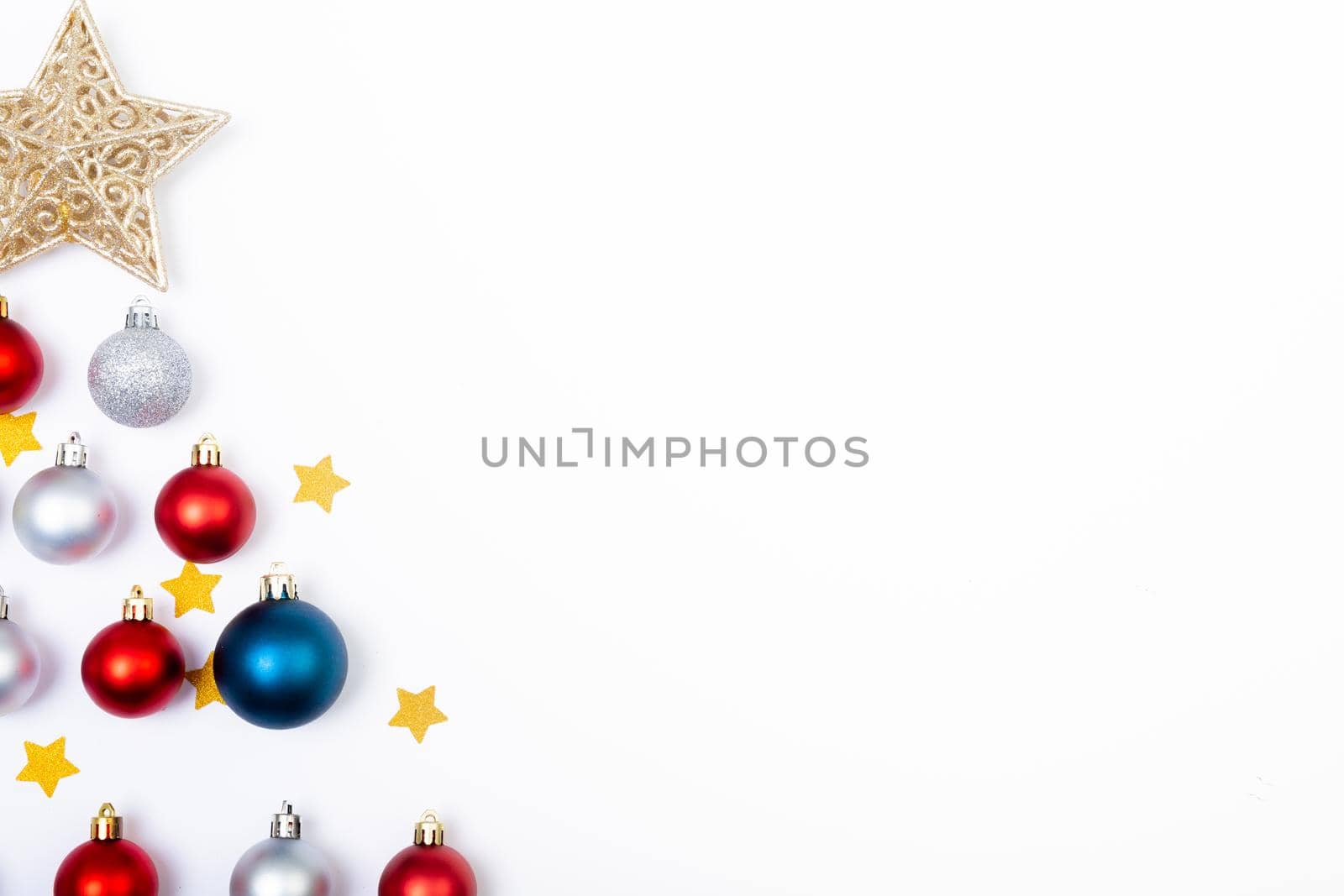Composition of baubles with stars in shape of christmas tree and copy space on white background. christmas, tradition and celebration concept.