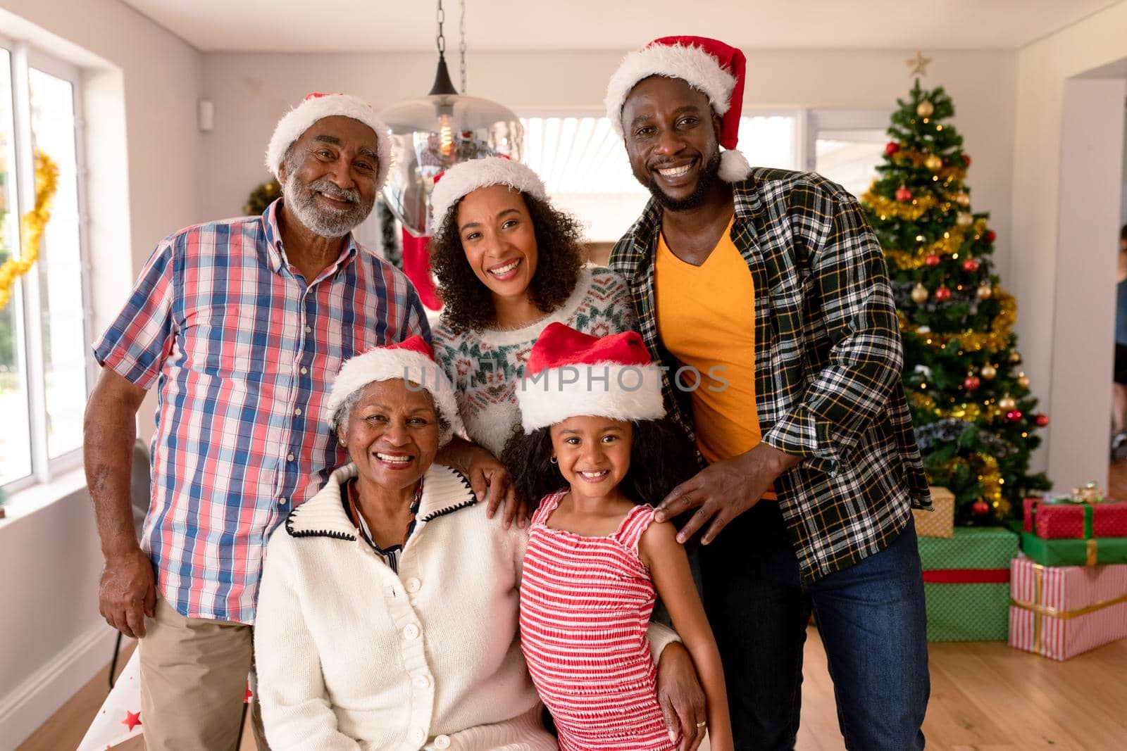 Happy multi generation family wearing santa hats, taking photo by Wavebreakmedia