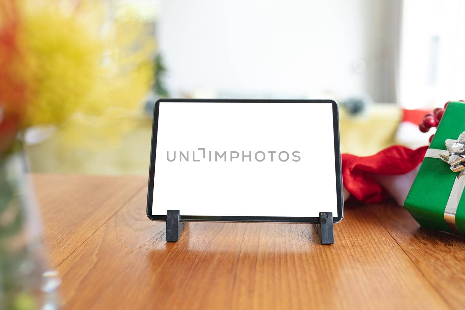 Tablet with copy space on screen lying on table with christmas decorations. christmas, festivity and communication technology.