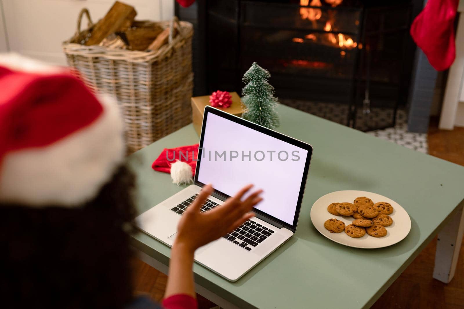 Back view of african american woman using laptop with copy space on screen. christmas, festivity and communication technology.