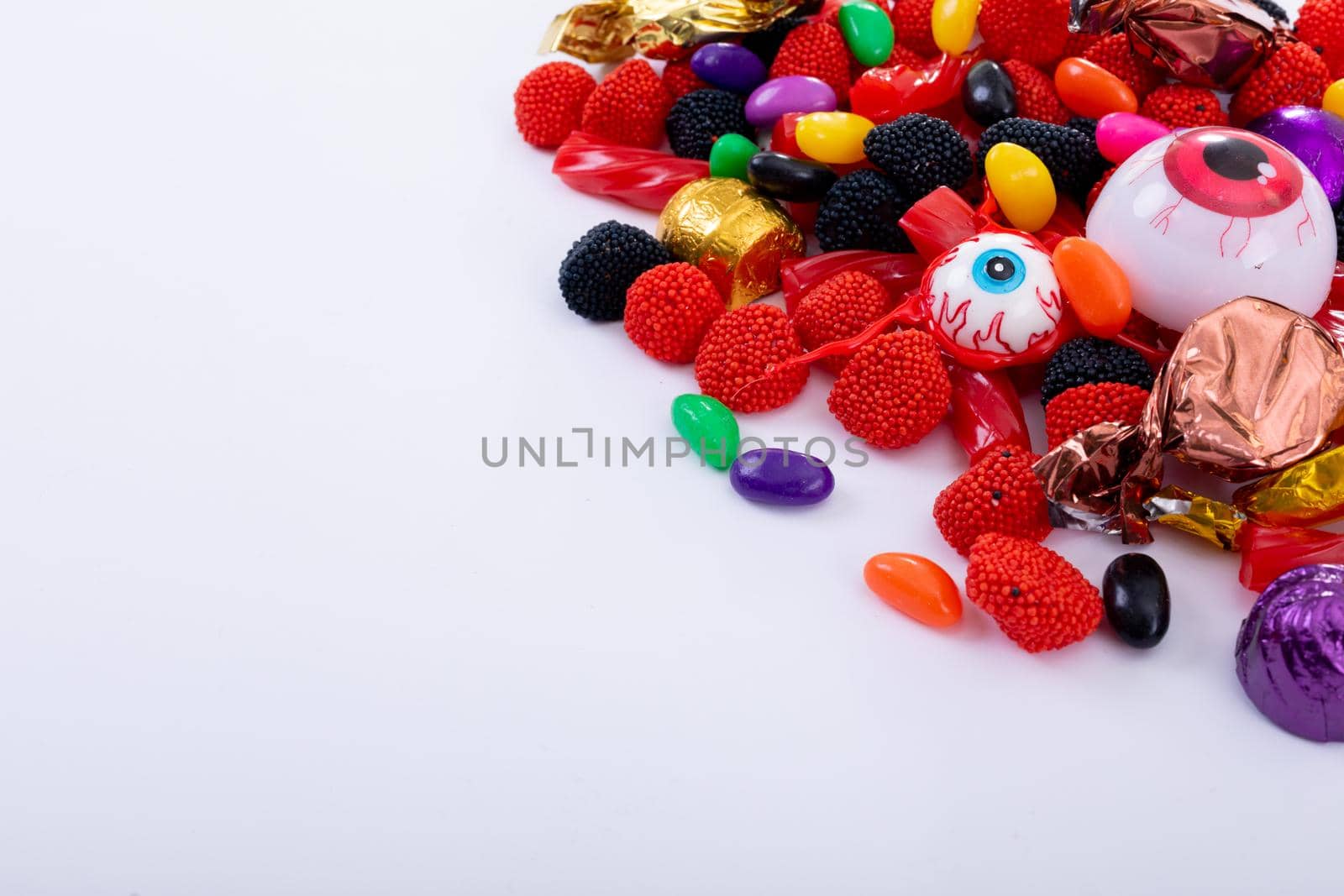 Composition of multiple halloween trick or treat eyeball sweets with copy space on white background. halloween tradition and celebration concept.