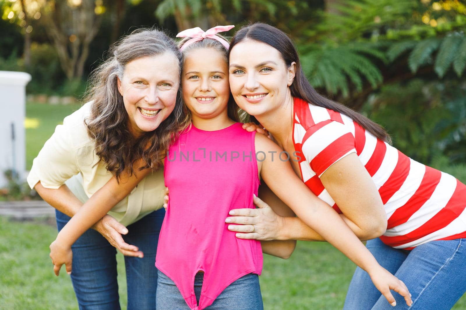 Portrait of smiling caucasian grandmother with adult daughter and granddaughter in garden by Wavebreakmedia