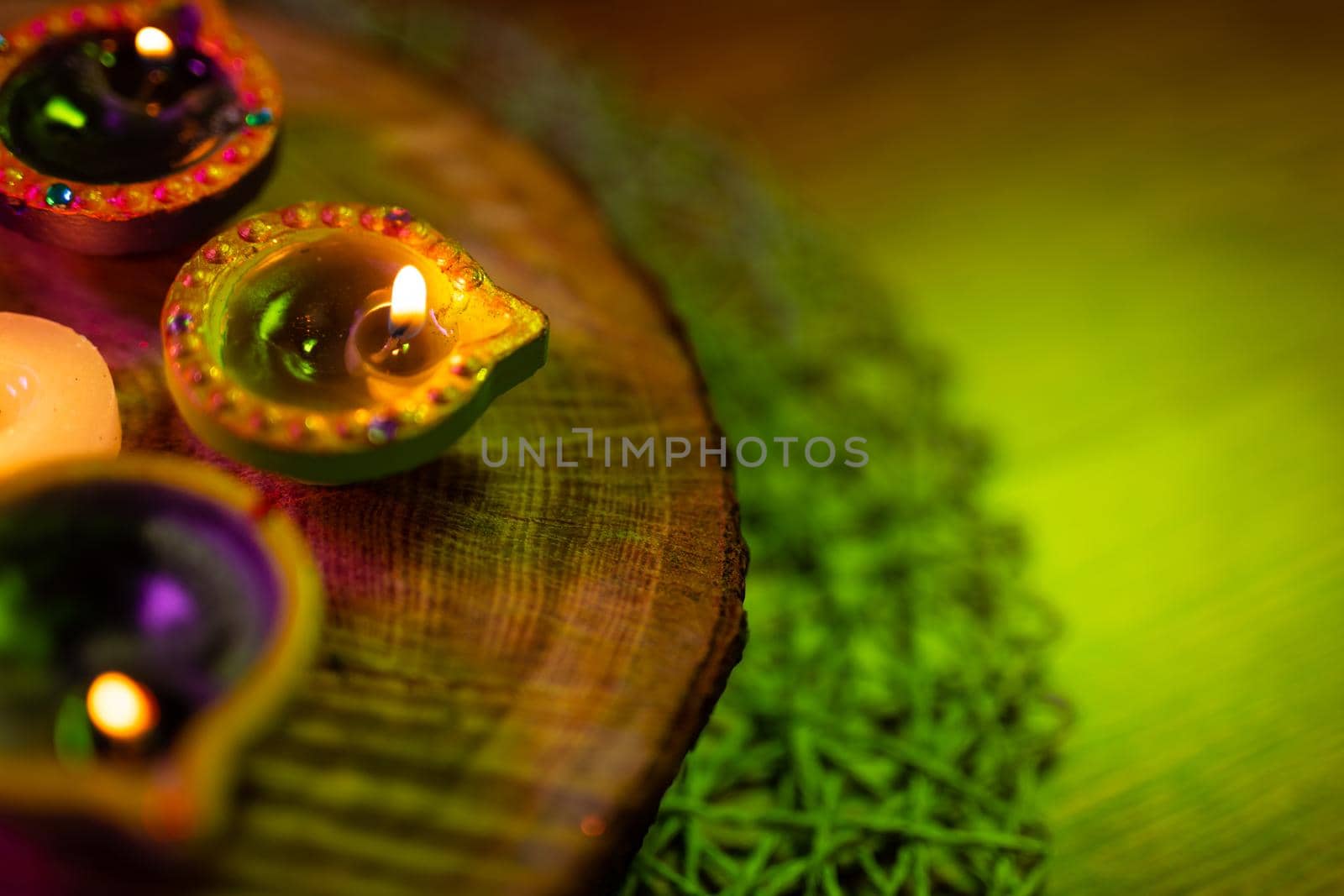 Lit candles in small decorative clay pots and tea light candle burning on round wooden board. celebration, religion, tradition and ceremony concept.