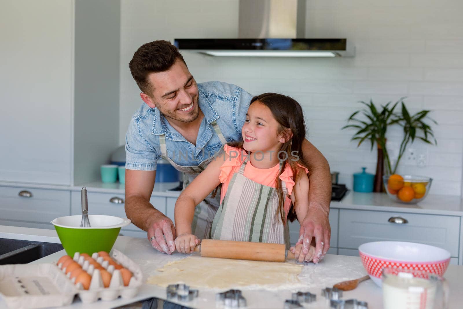 Happy caucasian father and daughter baking together, making cookies in kitchen. family time, having fun together at home.