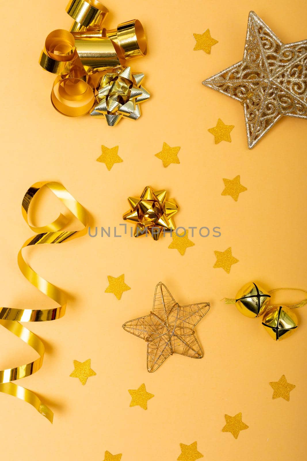 Composition of christmas decorations with ribbons, stars and copy space on yellow background by Wavebreakmedia