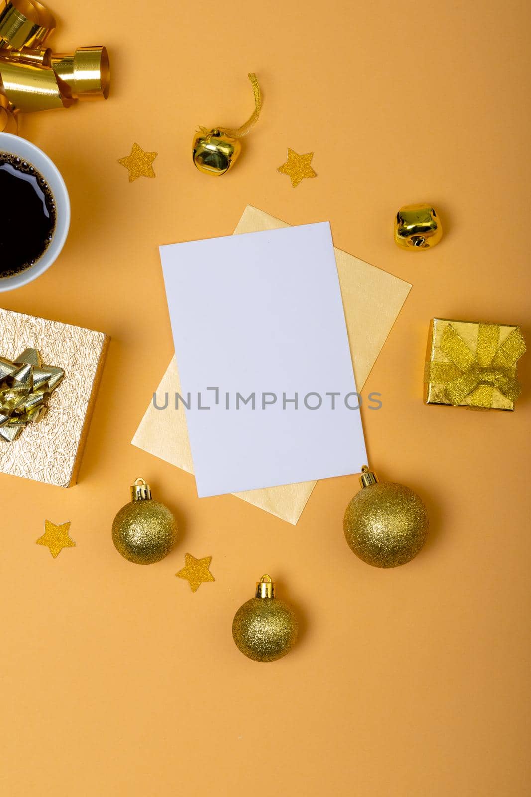 Composition of white card with copy space and christmas decorations with coffee on yellow background. christmas, tradition and celebration concept.