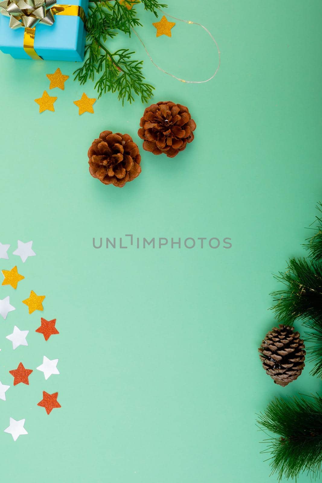 Composition of christmas decorations with pine cones and copy space on green background. christmas, tradition and celebration concept.