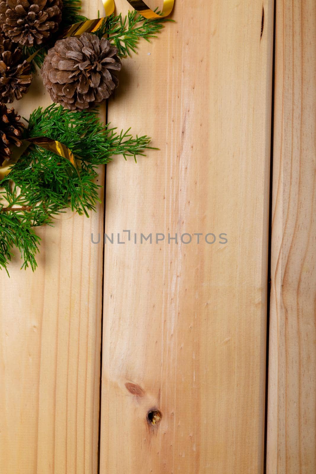 Composition of christmas decorations with pine cones and copy space on wooden background by Wavebreakmedia