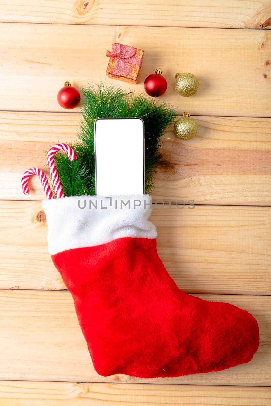 Composition of smartphone with copy space and christmas decorations on wooden background by Wavebreakmedia