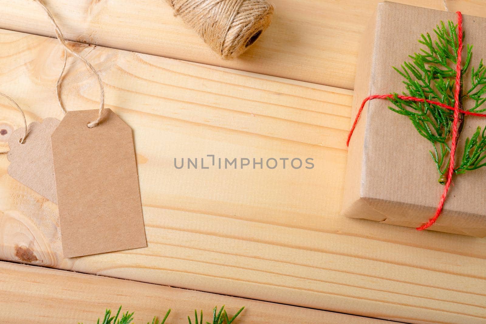 Composition of christmas decorations with present and copy space on wooden background. christmas, tradition and celebration concept.