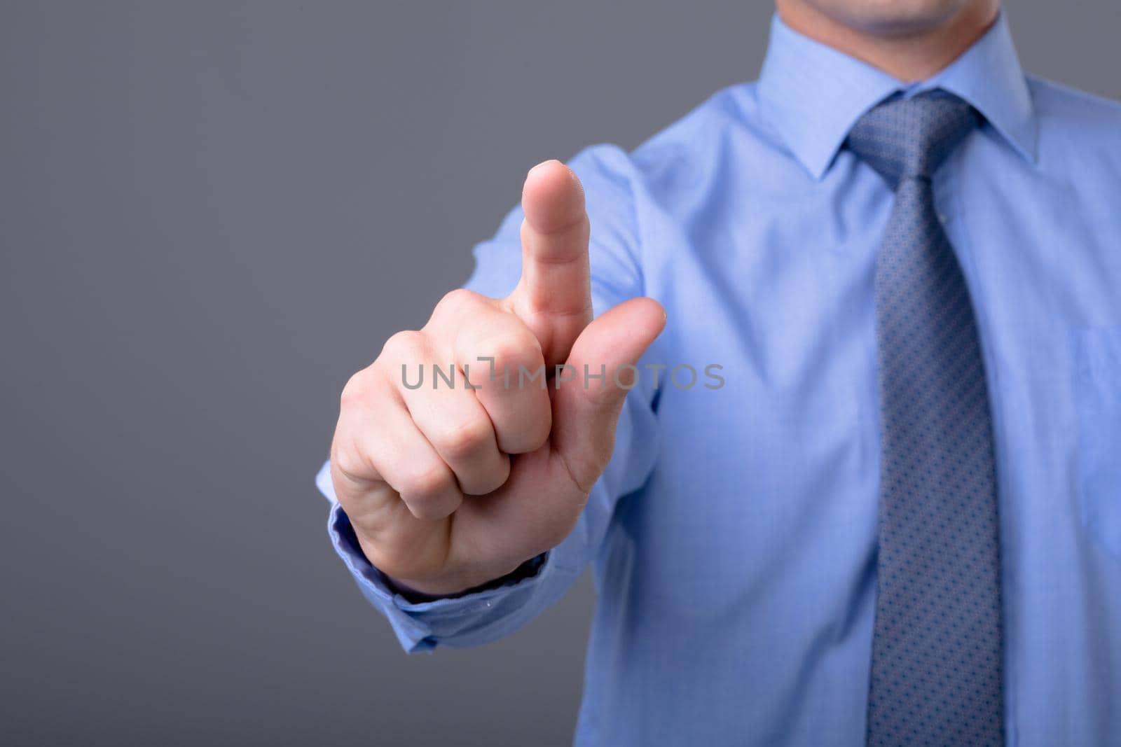 Midsection of caucasian businessman touching virtual interface, isolated on grey background. business technology, communication and growth concept.