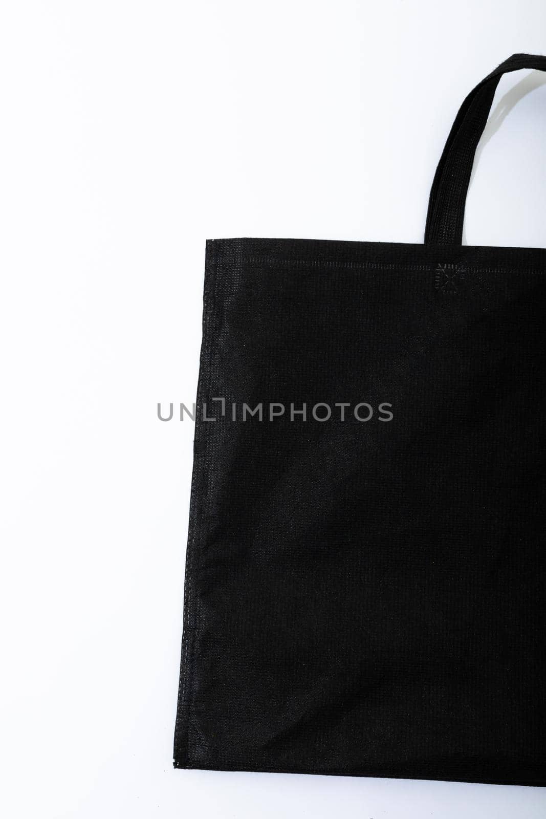 Composition of empty blag canvas shopping bag lying flat on white background with copy space. shopping and retail concept.