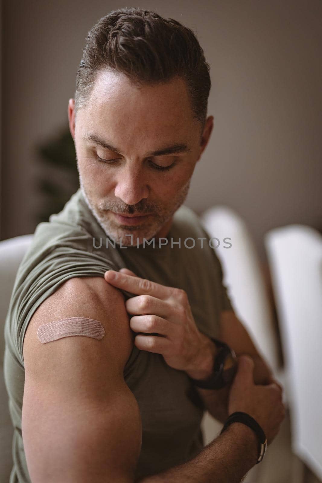 Caucasian man showing his vaccinated shoulder at home by Wavebreakmedia