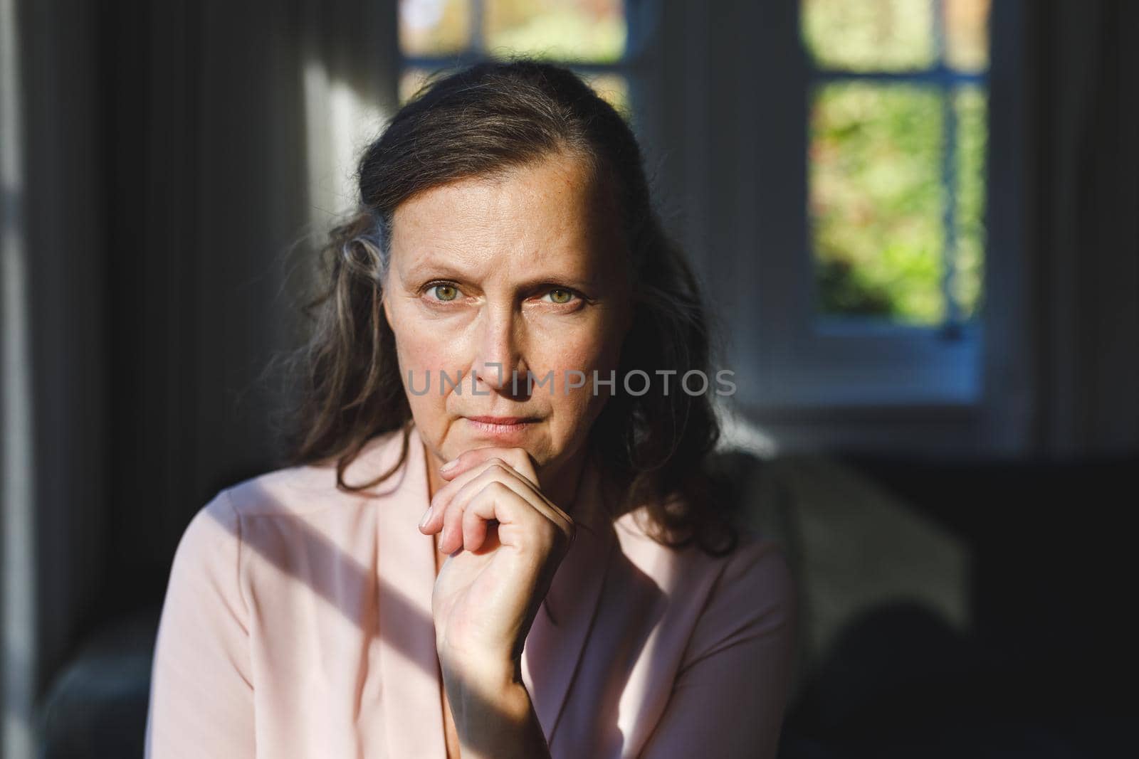 Portrait of thoughtful senior caucasian woman in bedroom, looking to camera. retirement lifestyle, spending time alone at home.