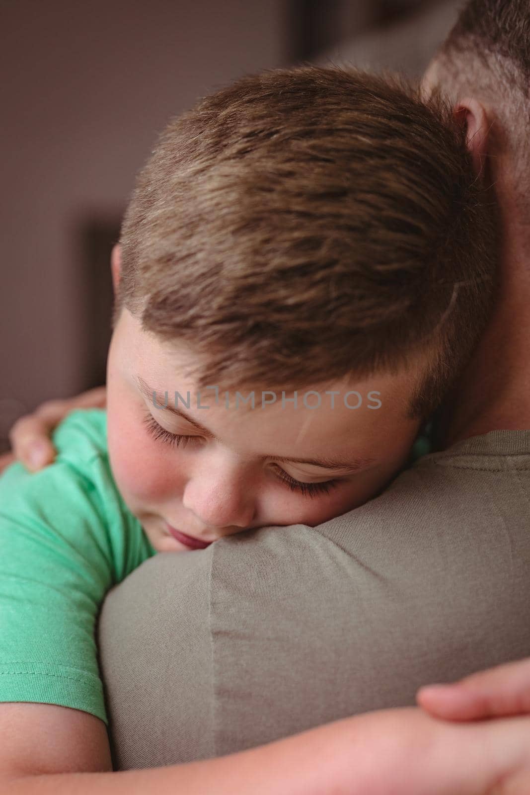 Close up view of caucasian boy hugging his father at home by Wavebreakmedia
