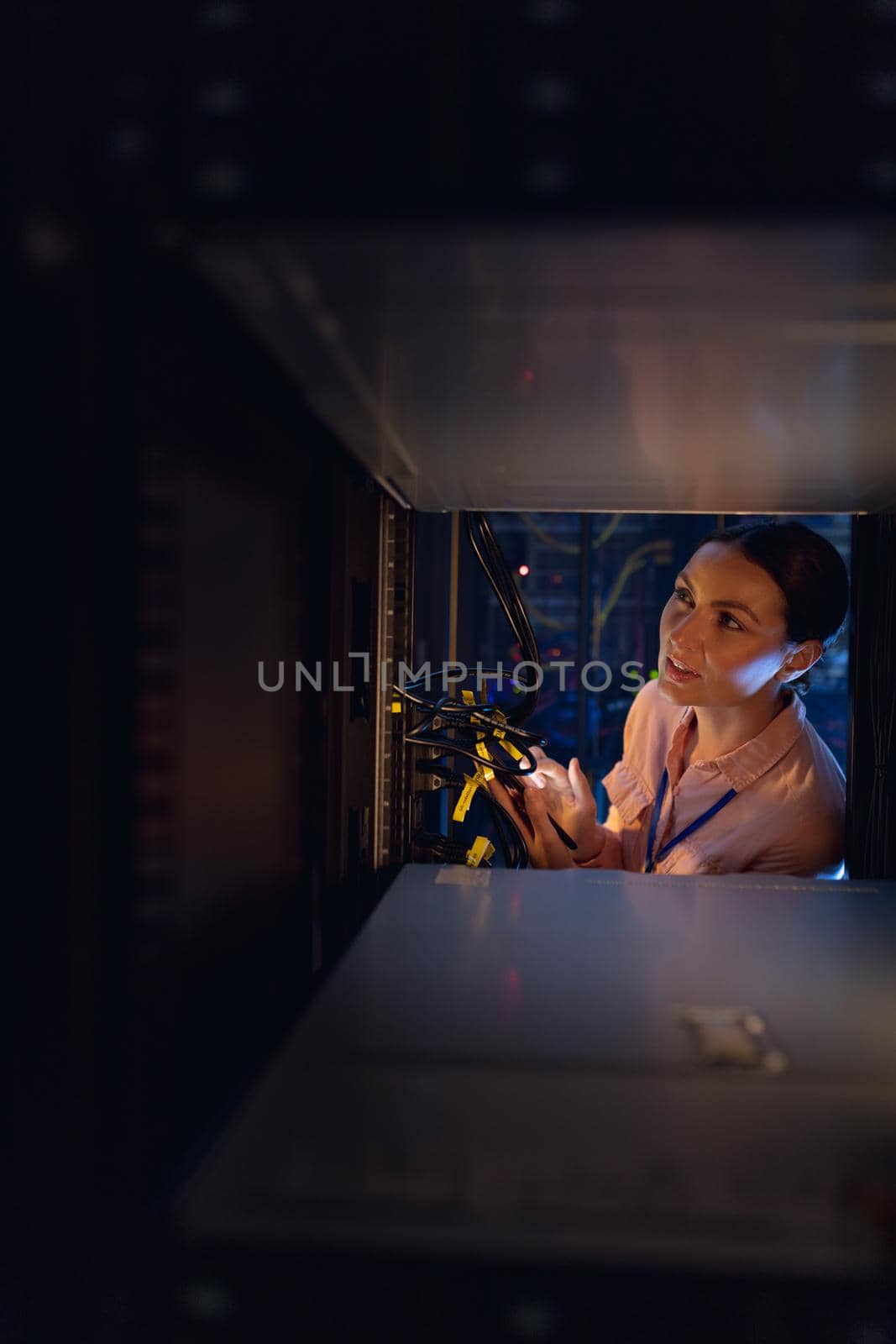 Caucasian female engineer inspecting the server in computer server room. database server management and maintenance concept