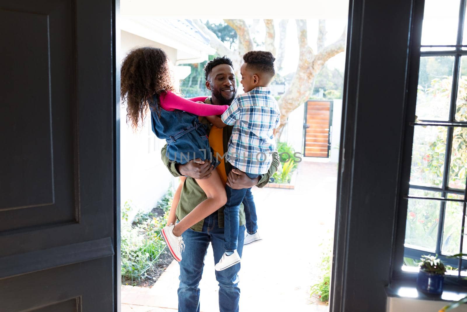 Happy african american children welcoming their father coming back home by Wavebreakmedia