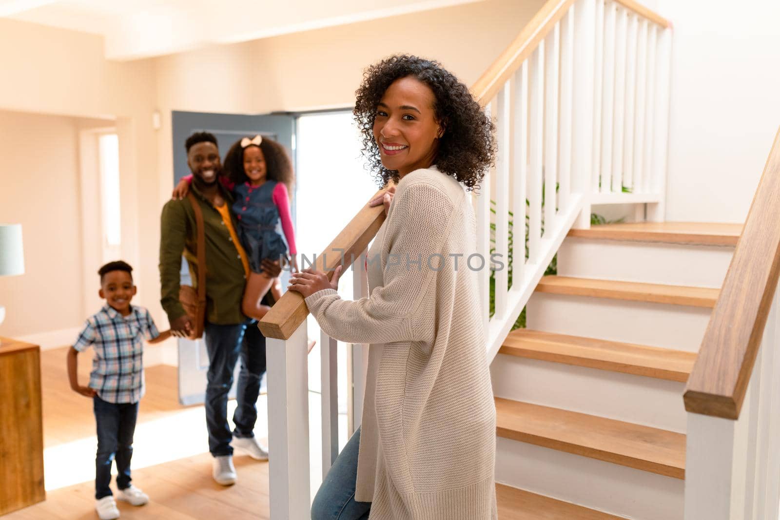 Happy african american family welcoming father coming back home. family time, having fun together at home.